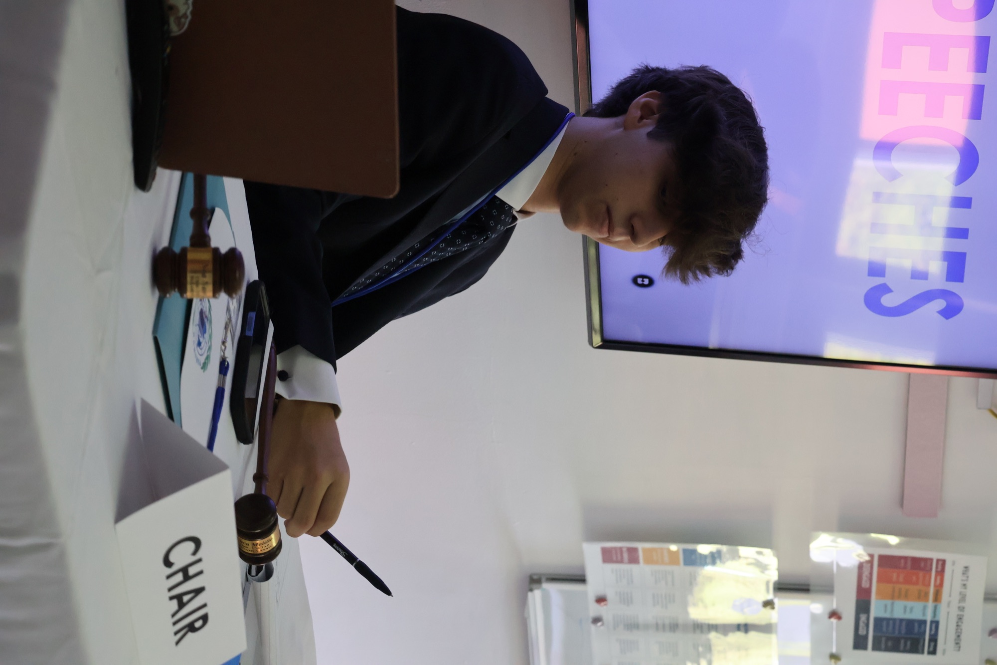 Luca G. Melillo seated at the UNCTAD chair’s table with a gavel at PANAMUN
